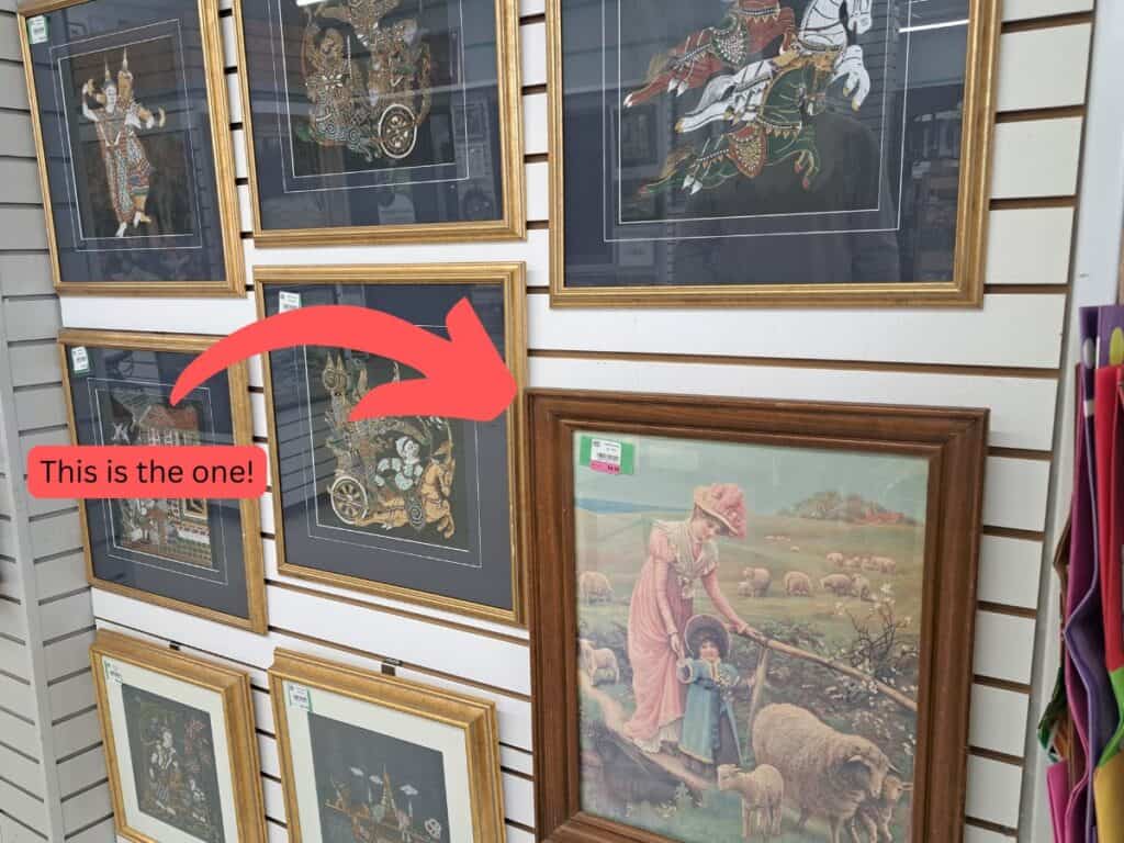 An old picture frame on the wall for sale at a thrift shop.