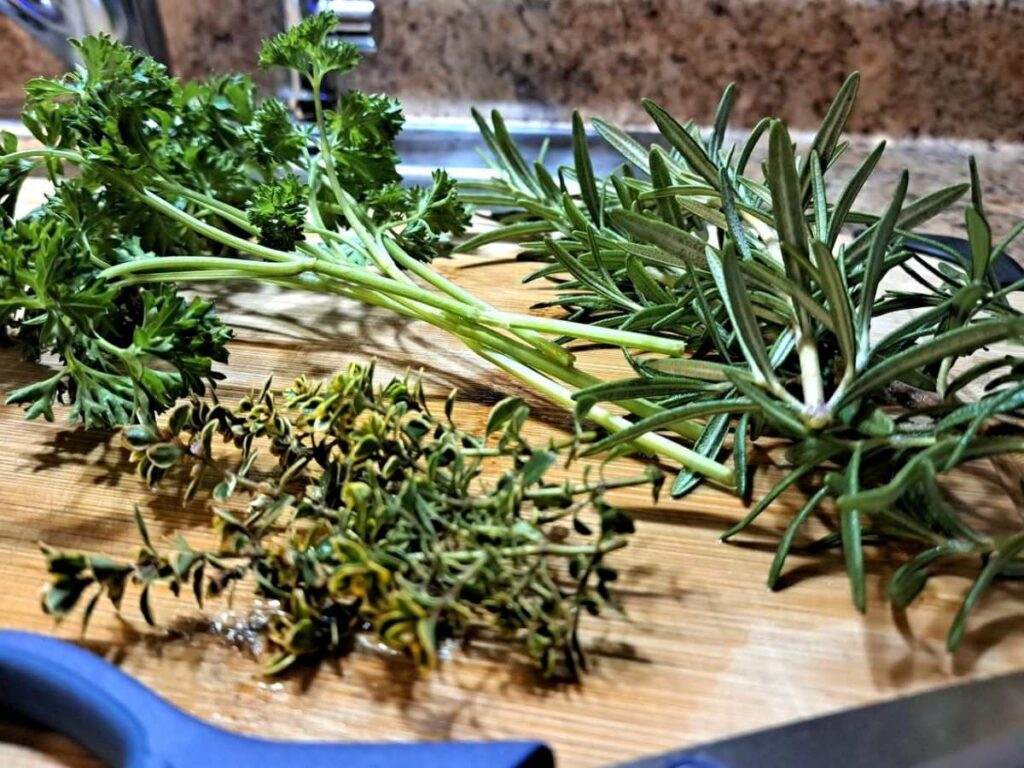 Fresh herbs laying on a cutting board.
