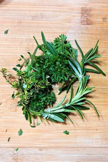 An herbal soup wreath sitting on a wooden cutting board.