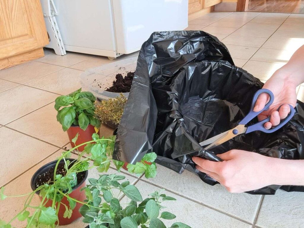 A woman cutting holes into a garbage bag that has been lined in a wicker basket.