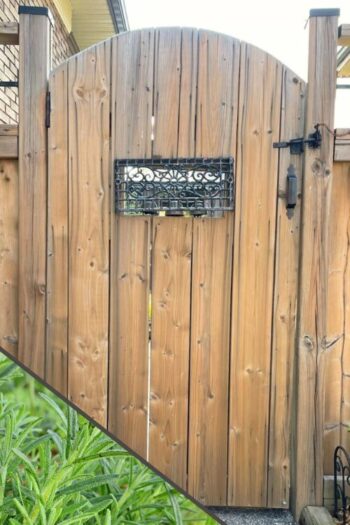 A wooden garden gate with rosemary in the lower left corner.