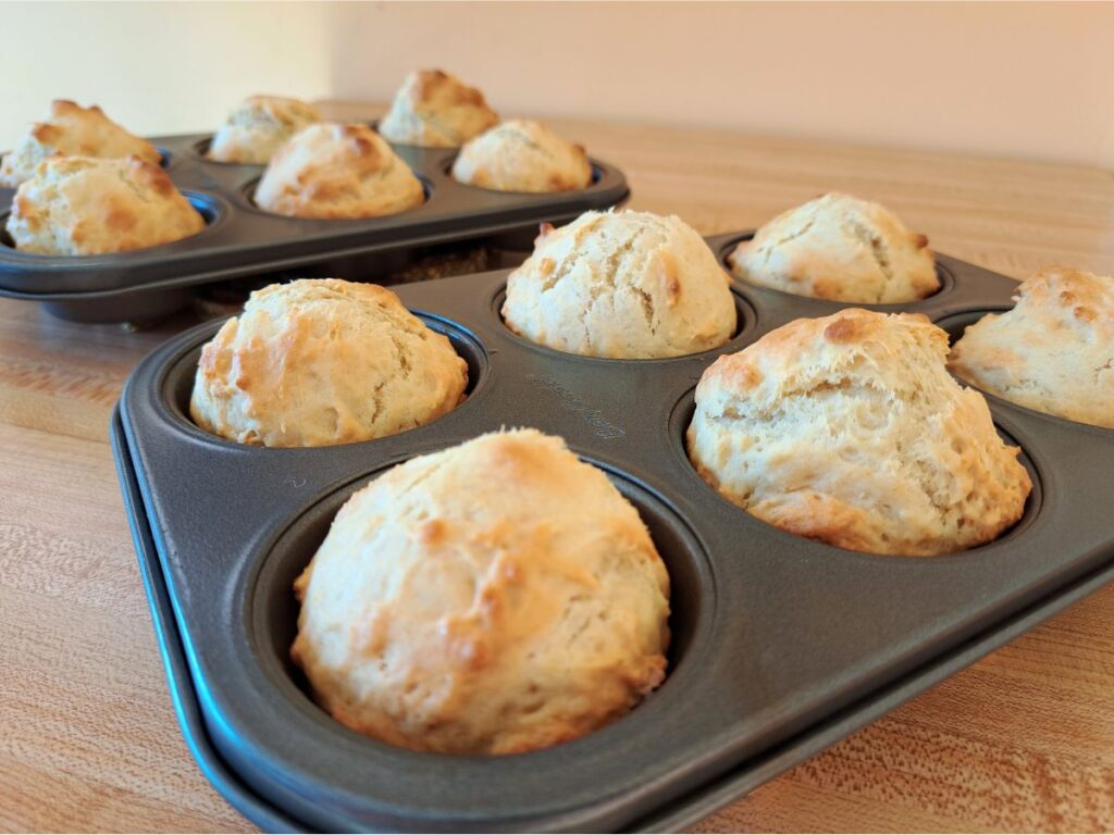 A close up of chamomile and honey sourdough discard muffins sitting on the counter in muffin tins.