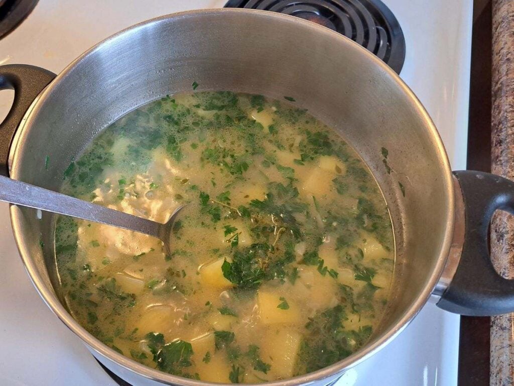 Stirring parsley in to the soup.