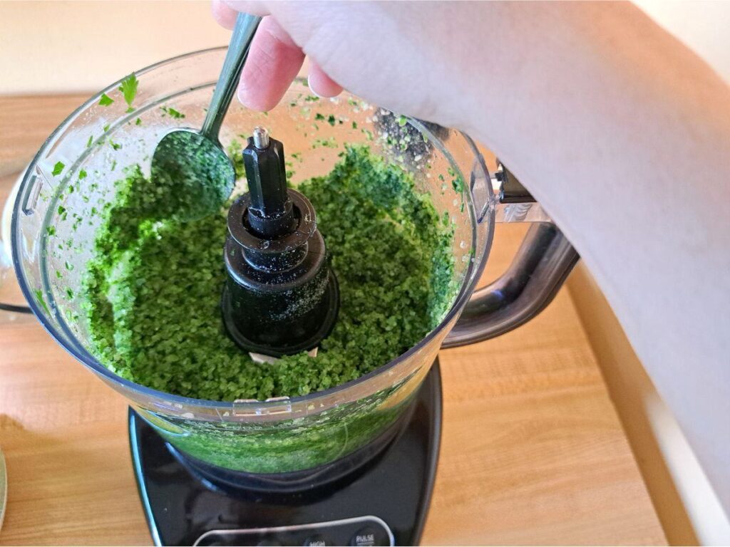 Scraping down the sides of the food processor.