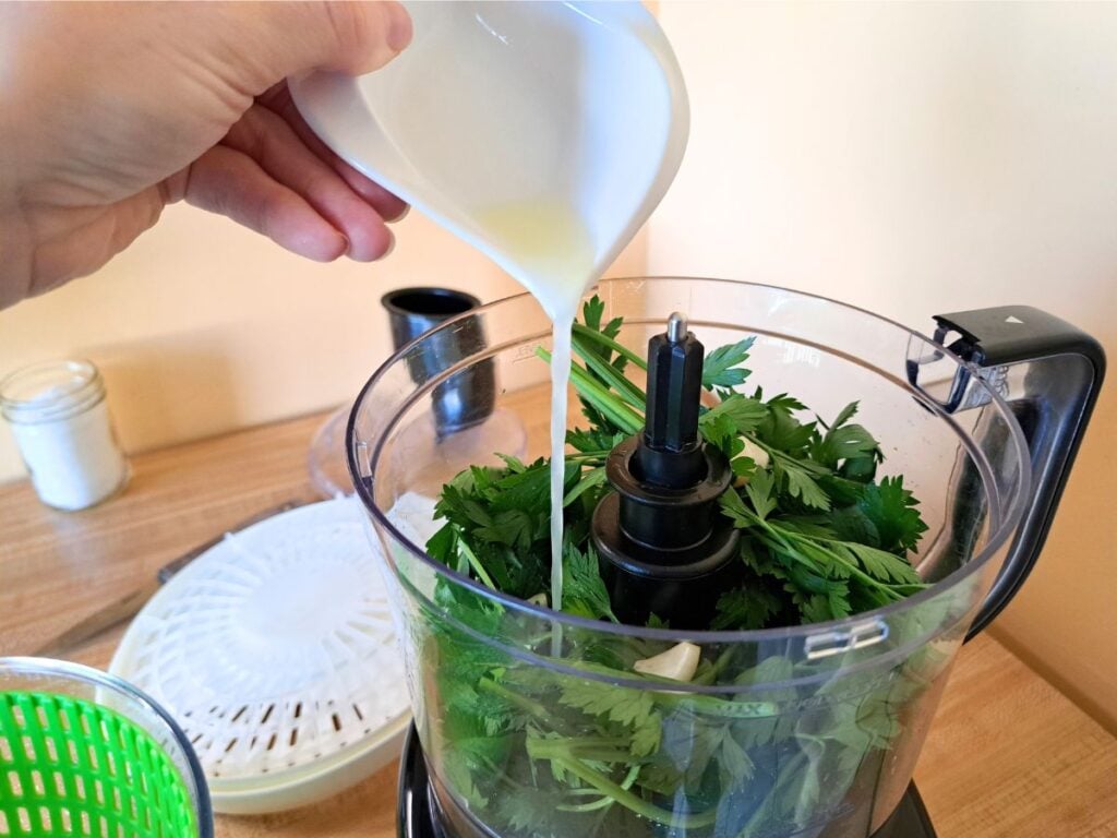 Adding lemon juice to the food processor.