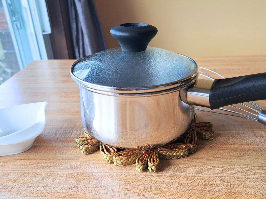 Steeping the honey lavender simple syrup in a metal saucepan with a clear glass lid.