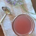 An overhead view of the lavender simple syrup in a clear glass canning jar.
